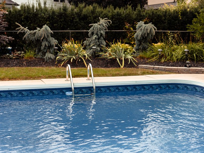 Piscina con agua cristalina en jardín de villa privada en Alicante